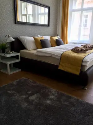 a bedroom with a large bed with yellow and blue pillows at Beautiful Apartments in Prague in Prague