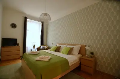 a bedroom with a large bed with a green blanket at Beautiful Apartments in Prague in Prague
