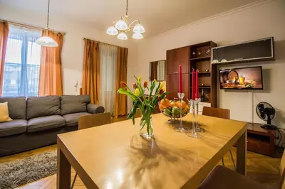 a living room with a wooden table with flowers on it at National Theater Ruterra Flat in Prague