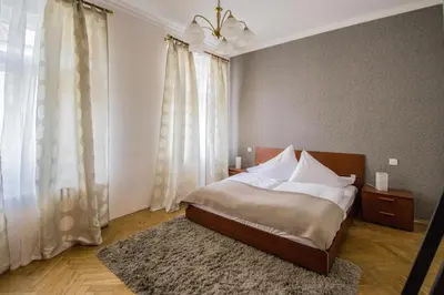a bedroom with a bed with white sheets and a rug at National Theater Ruterra Flat in Prague