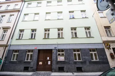 a white building with brown doors on a street at National Theater Ruterra Flat in Prague