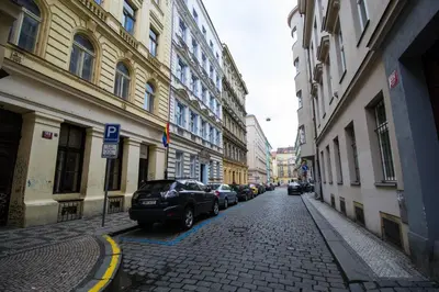 a cobblestone street with parked cars in a city at National Theater Ruterra Flat in Prague