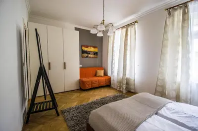 a bedroom with a bed and an orange chair at National Theater Ruterra Flat in Prague