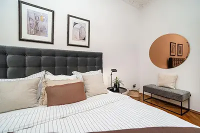 a bedroom with a large bed and a chair at Luxurious two-bedroom in the Old Town in Prague