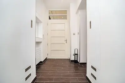 a hallway with a white door and a tile floor at Luxurious two-bedroom in the Old Town in Prague
