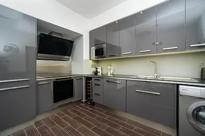 a kitchen with gray cabinets and a sink and a dishwasher at Luxurious two-bedroom in the Old Town in Prague