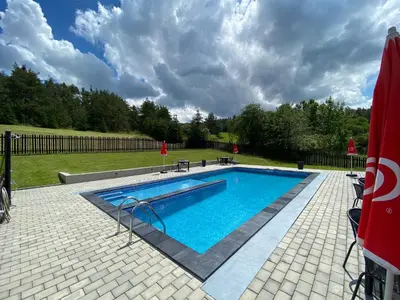 a swimming pool with blue water in a yard at Penzion Kamejk in Kamýk nad Vltavou