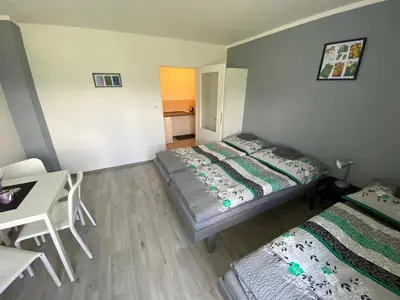 a bedroom with two beds and a desk and a table at Penzion Kamejk in Kamýk nad Vltavou