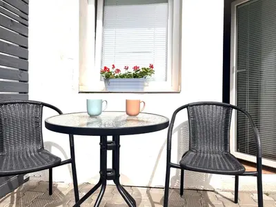 a table and chairs on a porch with a window at Ubytování na venkově Církvice in Zásmuky