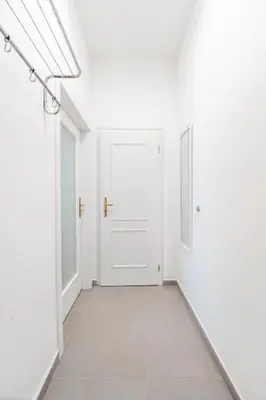 an empty corridor with white walls and a white door at Charming Apartment in Spain St in Prague