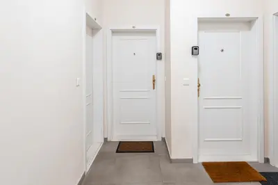 two white doors in a hallway with rugs at Charming Apartment in Spain St in Prague