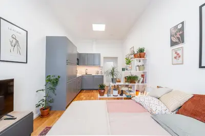 a living room with a couch and a kitchen at Charming Apartment in Spain St in Prague