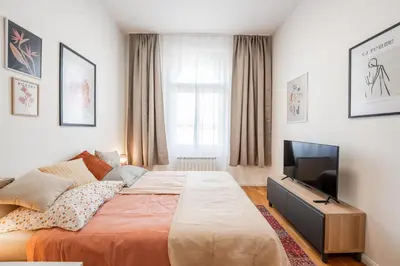 a bedroom with a bed and a flat screen tv at Charming Apartment in Spain St in Prague