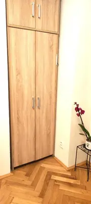 a large wooden cabinet in the corner of a room at Warm room in the beautiful Smíchov - Prague in Prague
