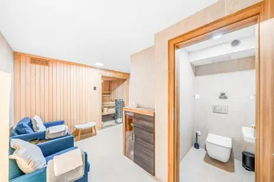 a bathroom with a blue couch and a sink at Dům u Prokopského údolí in Prague