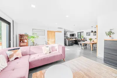 a living room with a pink couch and a kitchen at Dům u Prokopského údolí in Prague