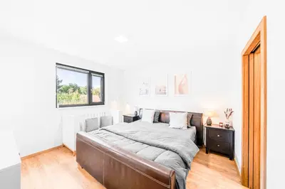 a bedroom with a large bed and a window at Dům u Prokopského údolí in Prague