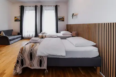 a bedroom with three beds and a couch at Jasminn Apartments in Prague