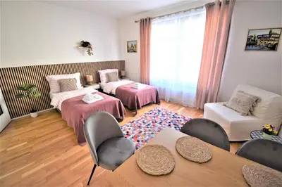 a living room with two beds and a table at Jasminn Apartments in Prague