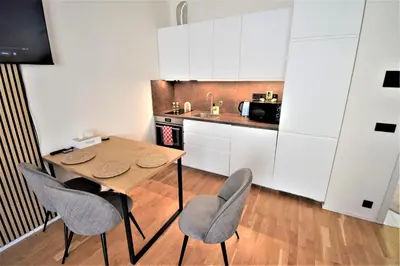 a small kitchen with a wooden table and chairs at Jasminn Apartments in Prague
