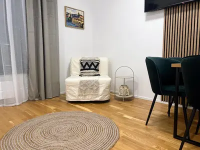 a living room with a white chair and a rug at Jasminn Apartments in Prague