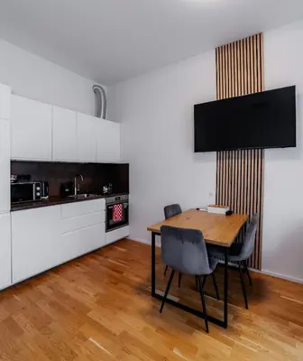 a kitchen and dining room with a wooden table and chairs at Jasminn Apartments in Prague