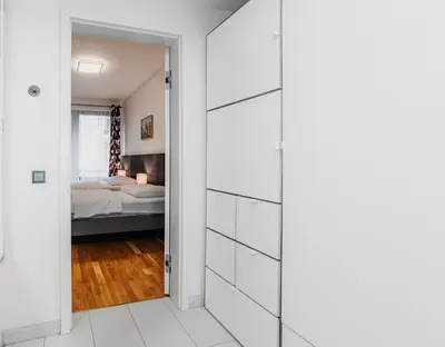 a bedroom with a bed and a door leading into a room at Jasminn Apartments in Prague