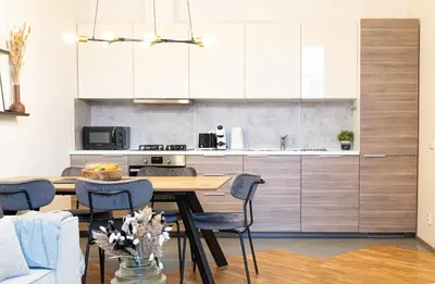a kitchen with a wooden table and blue chairs at Rentero Cozy Industrial 8min Dancing House Apartment, Prague in Prague
