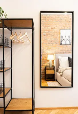 a mirror on a wall next to a bedroom at Rentero Cozy Industrial 8min Dancing House Apartment, Prague in Prague