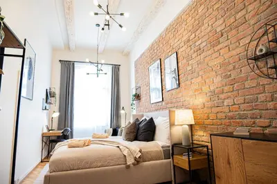 a bedroom with a brick wall and a bed at Rentero Cozy Industrial 8min Dancing House Apartment, Prague in Prague