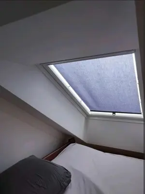 a small window in a bedroom with a bed at Cozy rooftop with balcony in Prague