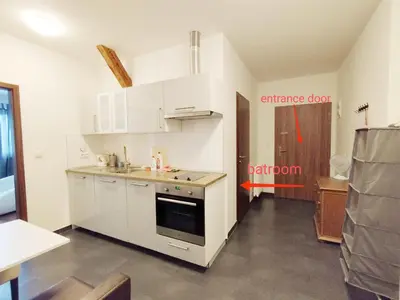 a kitchen with white cabinets and a stove top oven at Cozy rooftop with balcony in Prague