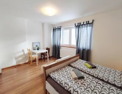 a bedroom with a bed and a table with a dining room at Cozy rooftop with balcony in Prague