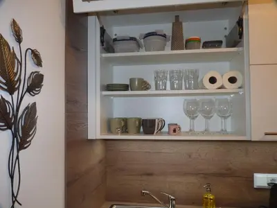 a kitchen cabinet with glasses and cups on it at Apartmán Trilobit in Beroun