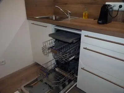 an open dishwasher in a kitchen with a sink at Apartmán Trilobit in Beroun