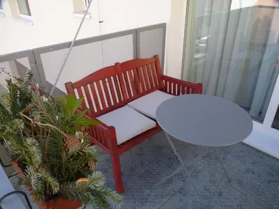 a red bench and a white table on a balcony at Apartmán Trilobit in Beroun