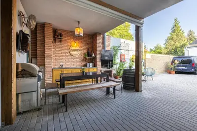 an outdoor patio with a bench and a grill at Penzion Rodos - Café in Prague