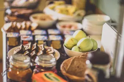 a table topped with bowls of fruit and jars of food at Penzion Rodos - Café in Prague