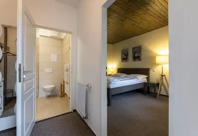 a small room with a bed and a bathroom at Penzion Rodos - Café in Prague