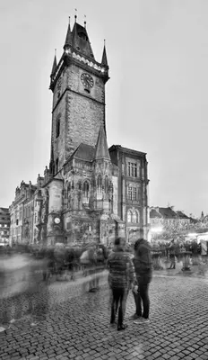 two people standing in front of an old building with a clock tower at Apartment VLTAVA in Prague