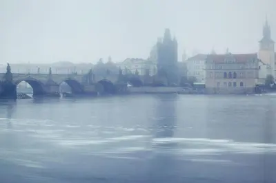 a large body of water with a bridge and buildings at Apartment VLTAVA in Prague