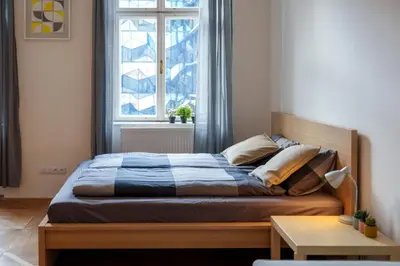 a bed in a bedroom with a large window at Naru house 6 in Prague