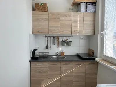 a kitchen with wooden cabinets and a sink at Sunny minimalistic flat near metro Opatov in Prague