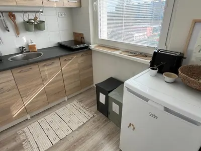 a small kitchen with a sink and a counter at Sunny minimalistic flat near metro Opatov in Prague