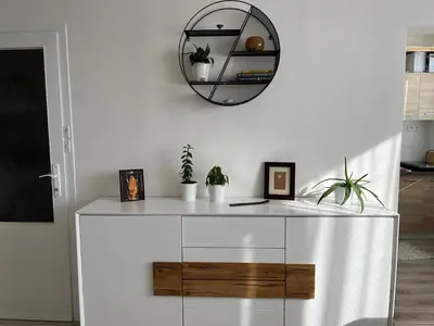 a white cabinet with a mirror on a wall at Sunny minimalistic flat near metro Opatov in Prague