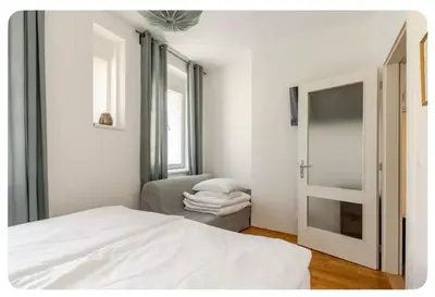 a bedroom with a bed and a chair and a mirror at Apartmán l Praha centrum in Prague