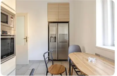 a kitchen with a table and a stainless steel refrigerator at Apartmán l Praha centrum in Prague