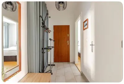 a hallway with a wooden door and a mirror at Apartmán l Praha centrum in Prague