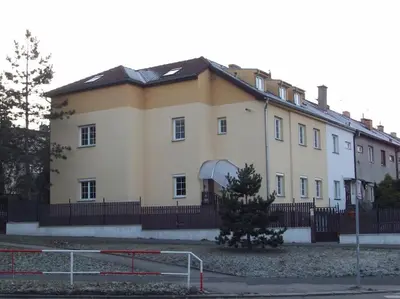 a large building with a fence in front of it at Harrison Homes Prague Apartment 01 Terrace and Parking in Prague