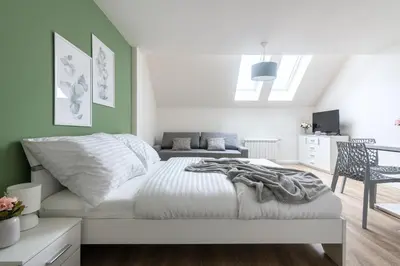 a bedroom with a white bed and a couch at Central Haven Apartments in Prague